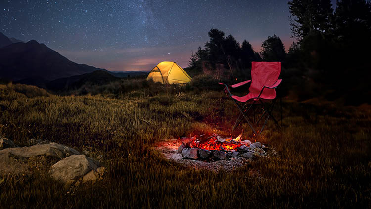 Lit campfire under a sky full of stars