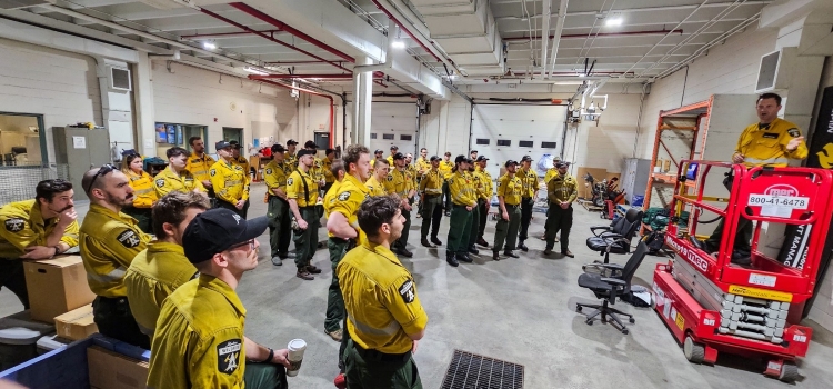 Firefighters receive a briefing ahead of their departure to California