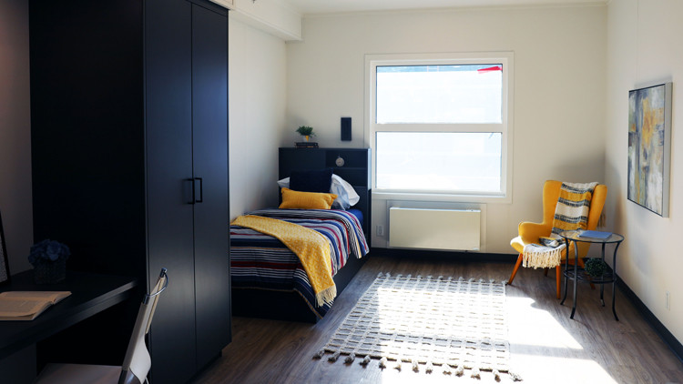 Room with single bed, chair and window.