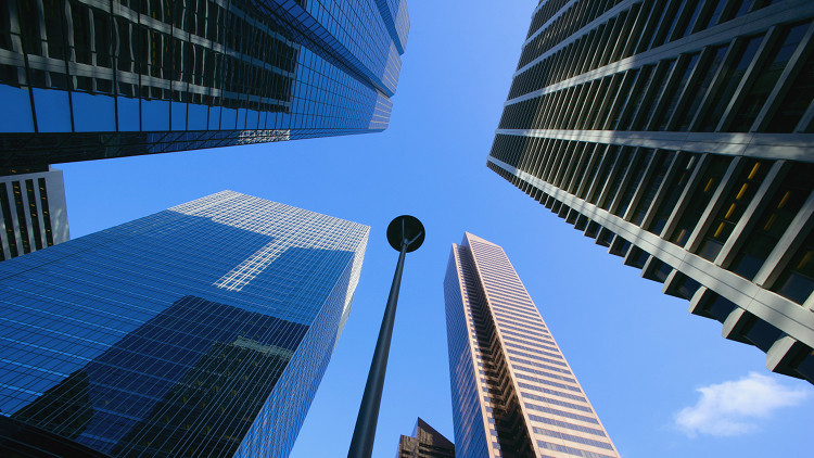 Looking up at Calgary downtown skyscrapers with a blue sky in the background