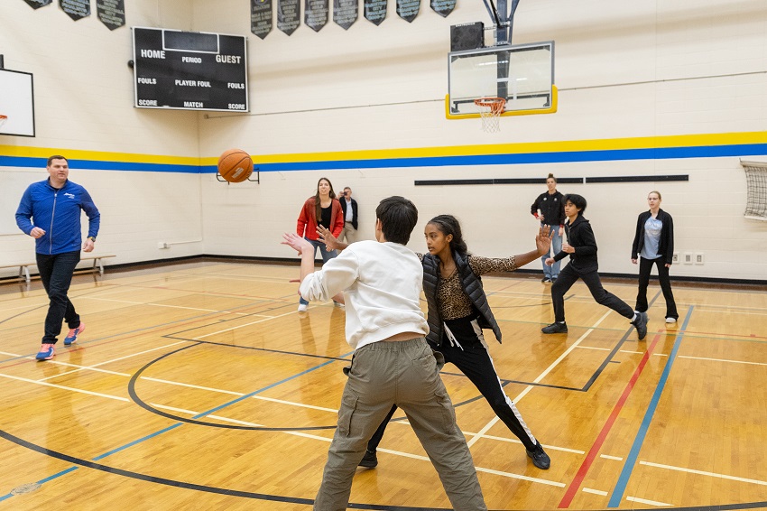 Minister of Tourism and Sport, Olympians Michelle and Katherine Plouffe, and Grade 8 and 9 students from Holy Family Catholic Elementary/Jr High School in Edmonton play 3x3 backetball